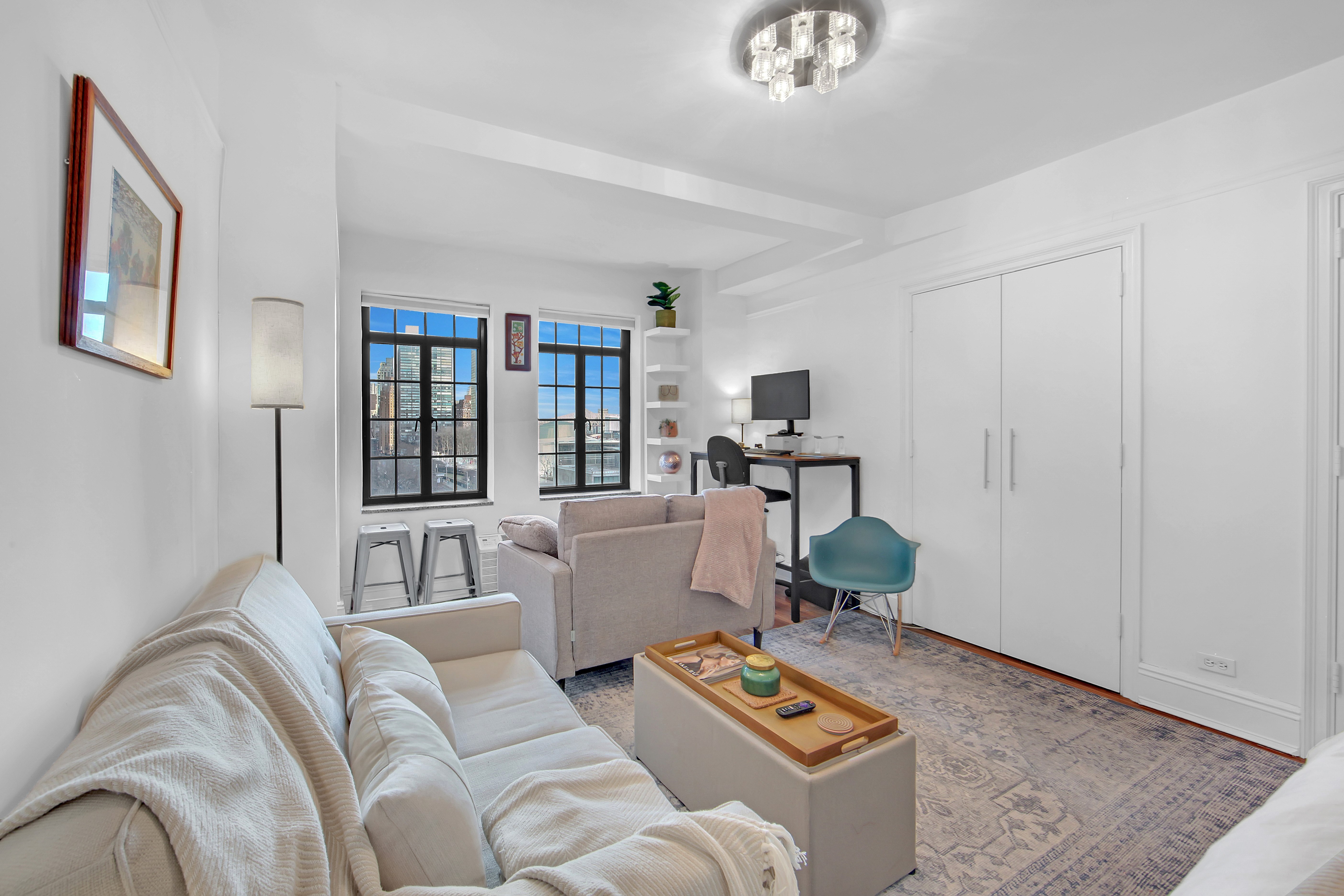 5 Tudor City Place, Unit 539 Manhattan, NY 10017 - Photo 9 of 12 a living room with furniture and a window
