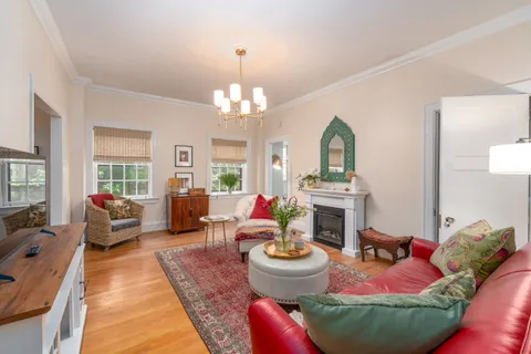 a living room with furniture chandelier and a fireplace