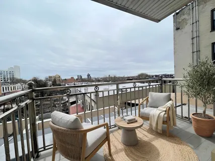 a view of a balcony with two chairs and a potted plant