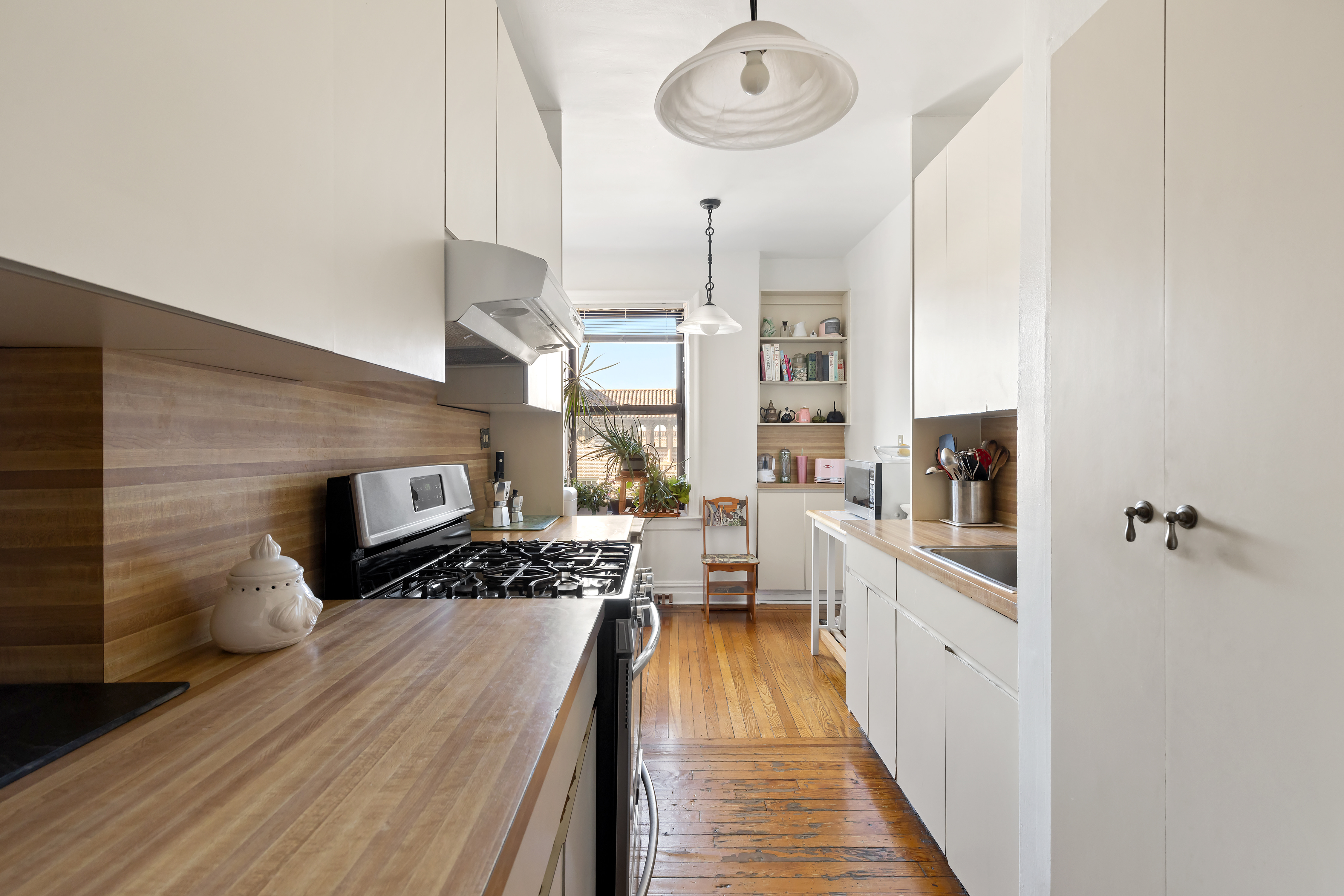 83-10 35th Avenue, Unit 5O Queens, NY 11372 - Photo 2 of 8 a kitchen with stainless steel appliances granite countertop a stove and cabinets