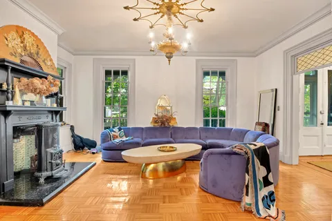 a living room with furniture a chandelier and a fireplace