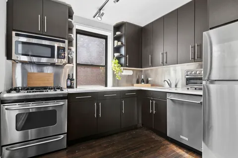 a kitchen with stainless steel appliances a stove microwave and sink