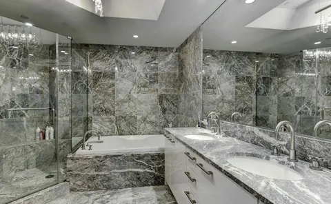 a bathroom with a granite countertop sink a mirror and a shower