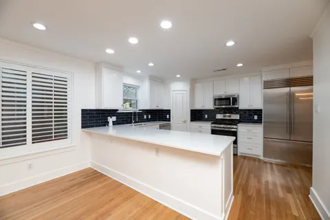 a kitchen with stainless steel appliances granite countertop a refrigerator and a stove top oven