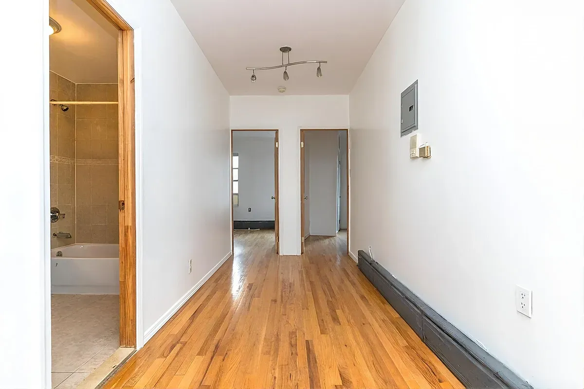 a view of a hallway with wooden floor