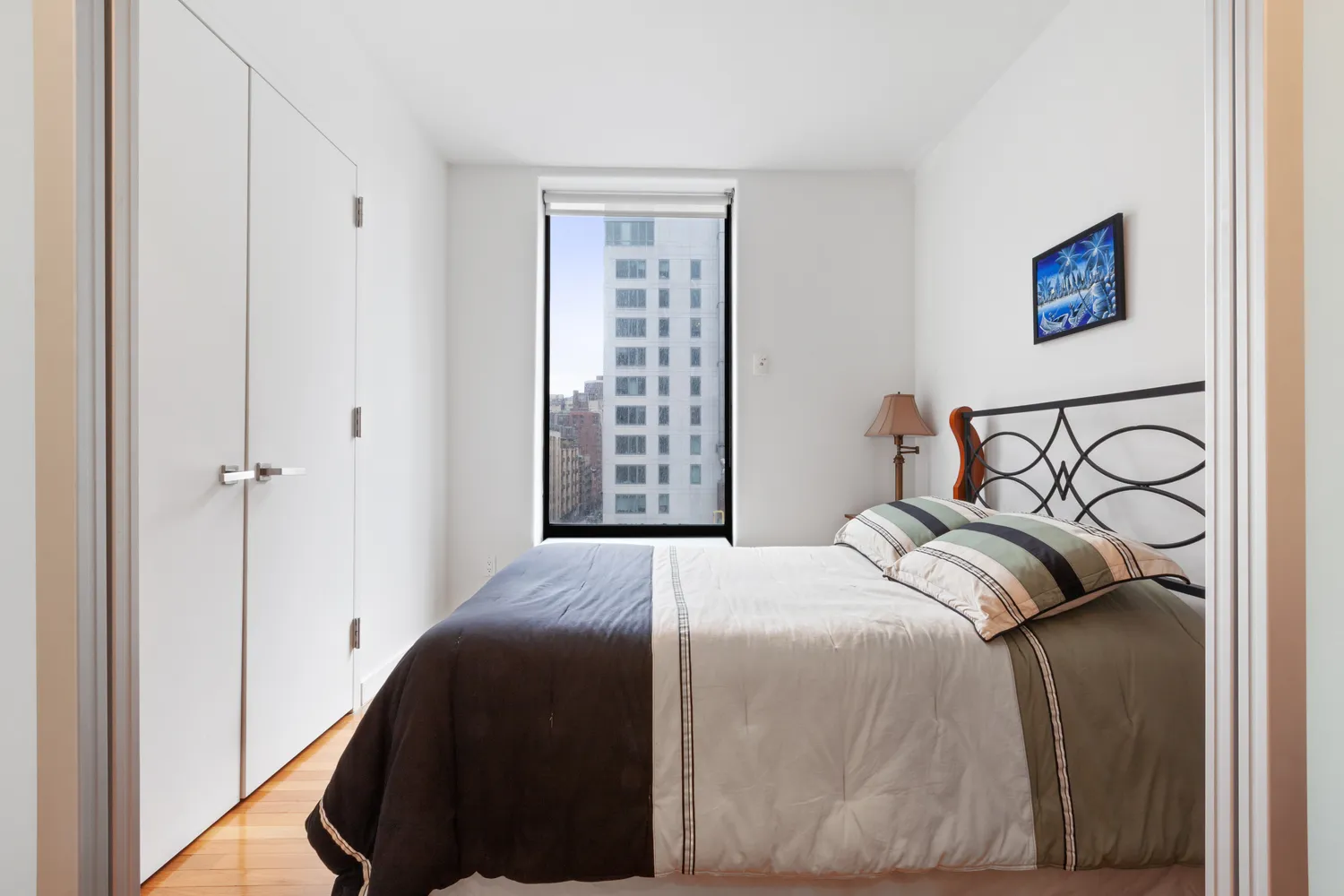 a bedroom with a bed and a painting on the wall