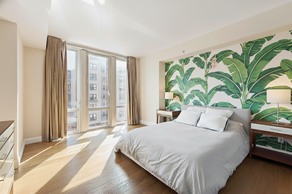 177 9th Avenue, Unit 4F Manhattan, NY 10011 - Photo 4 of 13 a bedroom with a large bed and a large window with potted plants