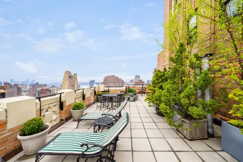 a view of a balcony with chairs and potted plants