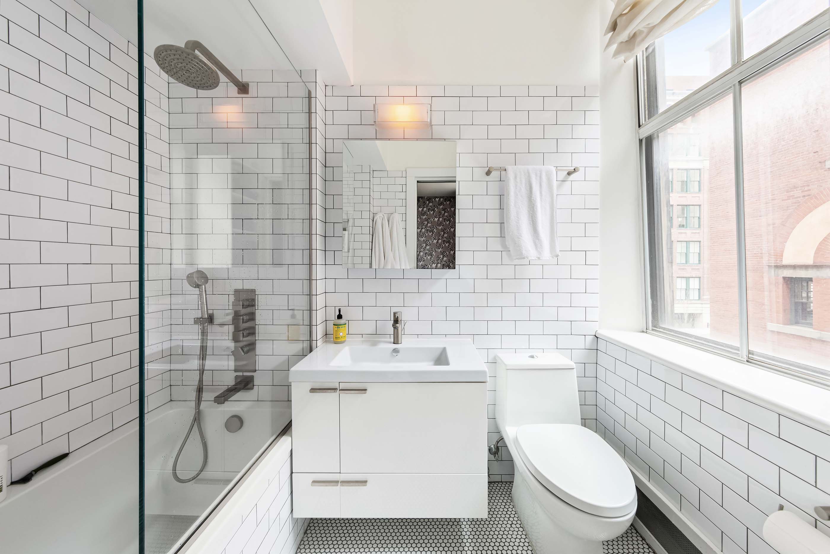 57 Laight Street, Unit 3 Manhattan, NY 10013 - Photo 11 of 15 a bathroom with a granite countertop toilet a sink a mirror and shower
