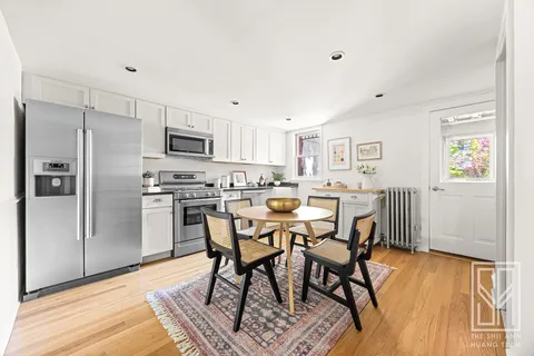 a kitchen with stainless steel appliances a dining table chairs refrigerator and sink