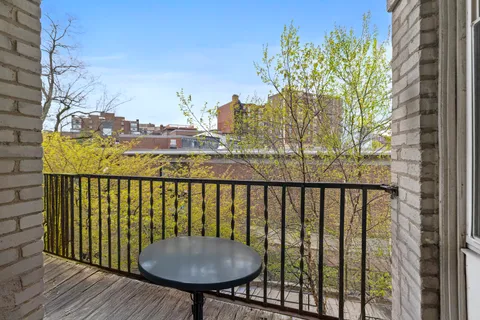 a view of a balcony with a table and chairs