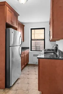 a kitchen with stainless steel appliances granite countertop a refrigerator a sink a stove and a refrigerator