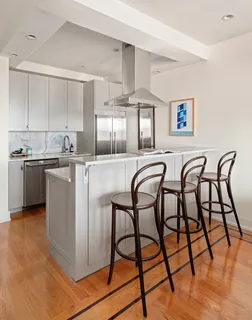 a kitchen with stainless steel appliances granite countertop table chairs sink and cabinets