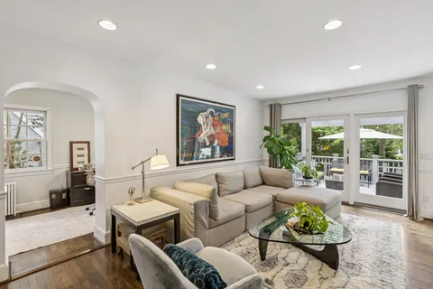 a living room with furniture potted plant and a large window