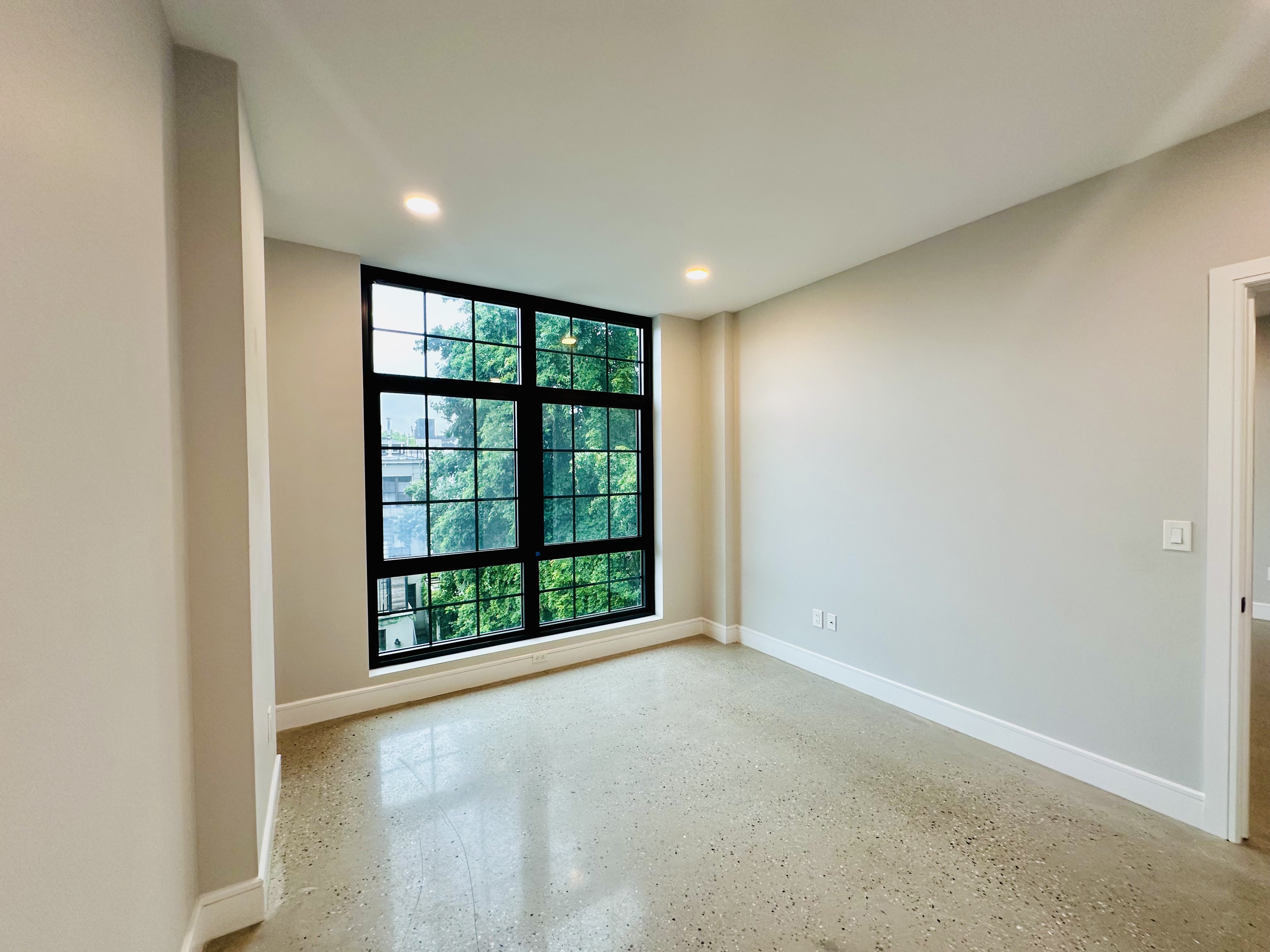 23 Bleecker Street, Unit 4E Brooklyn, NY 11221 - Photo 4 of 11 an empty room with large windows