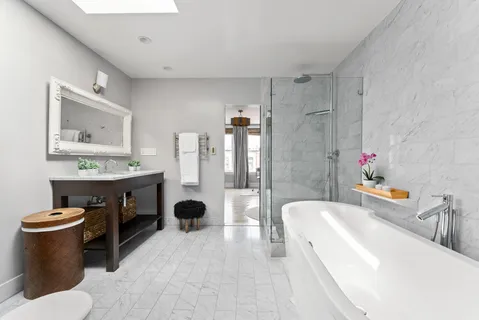 a bathroom with a tub sink toilet and mirror