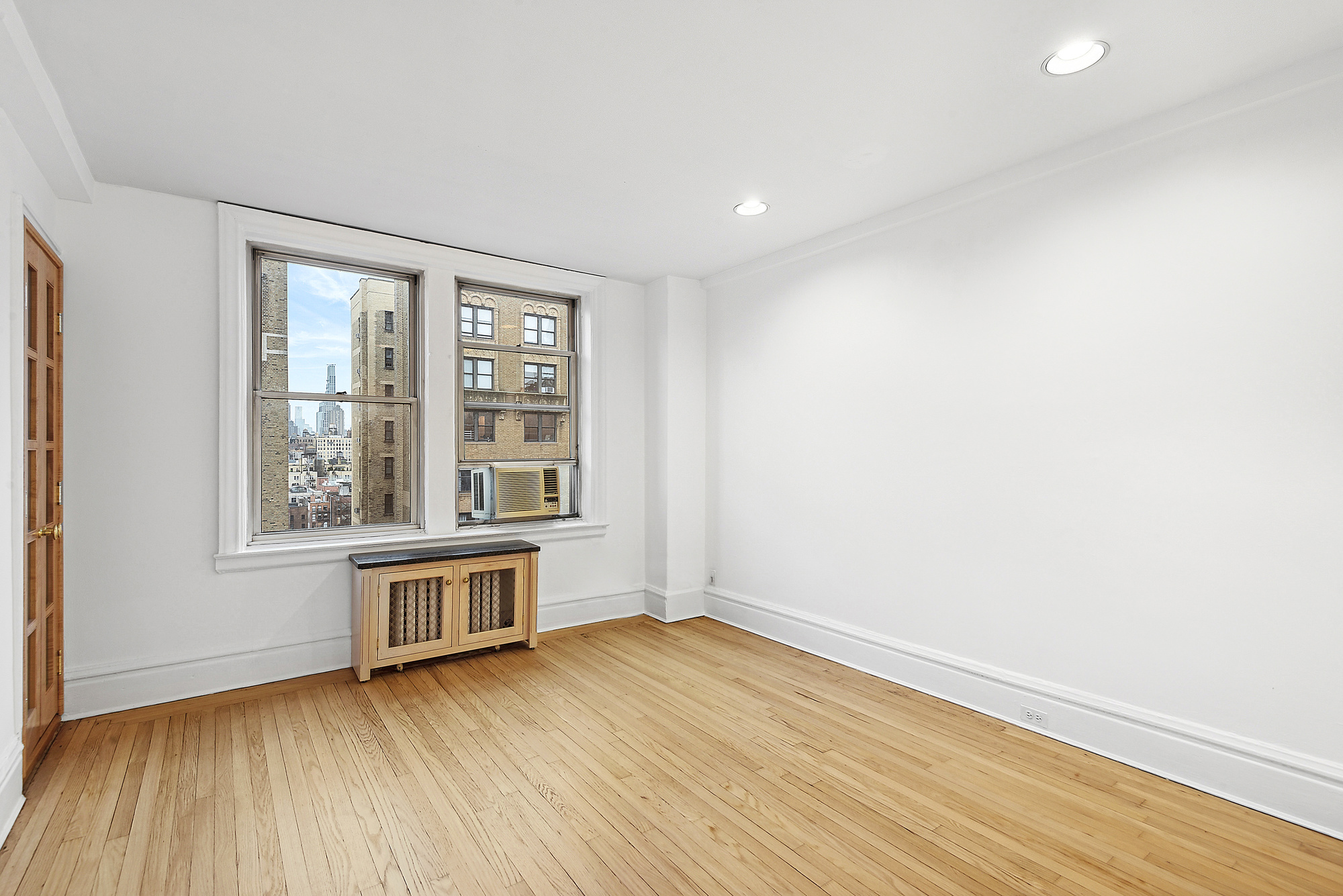 145 West 86th Street, Unit 12B Manhattan, NY 10024 - Photo 5 of 12 an empty room with wooden floor and windows