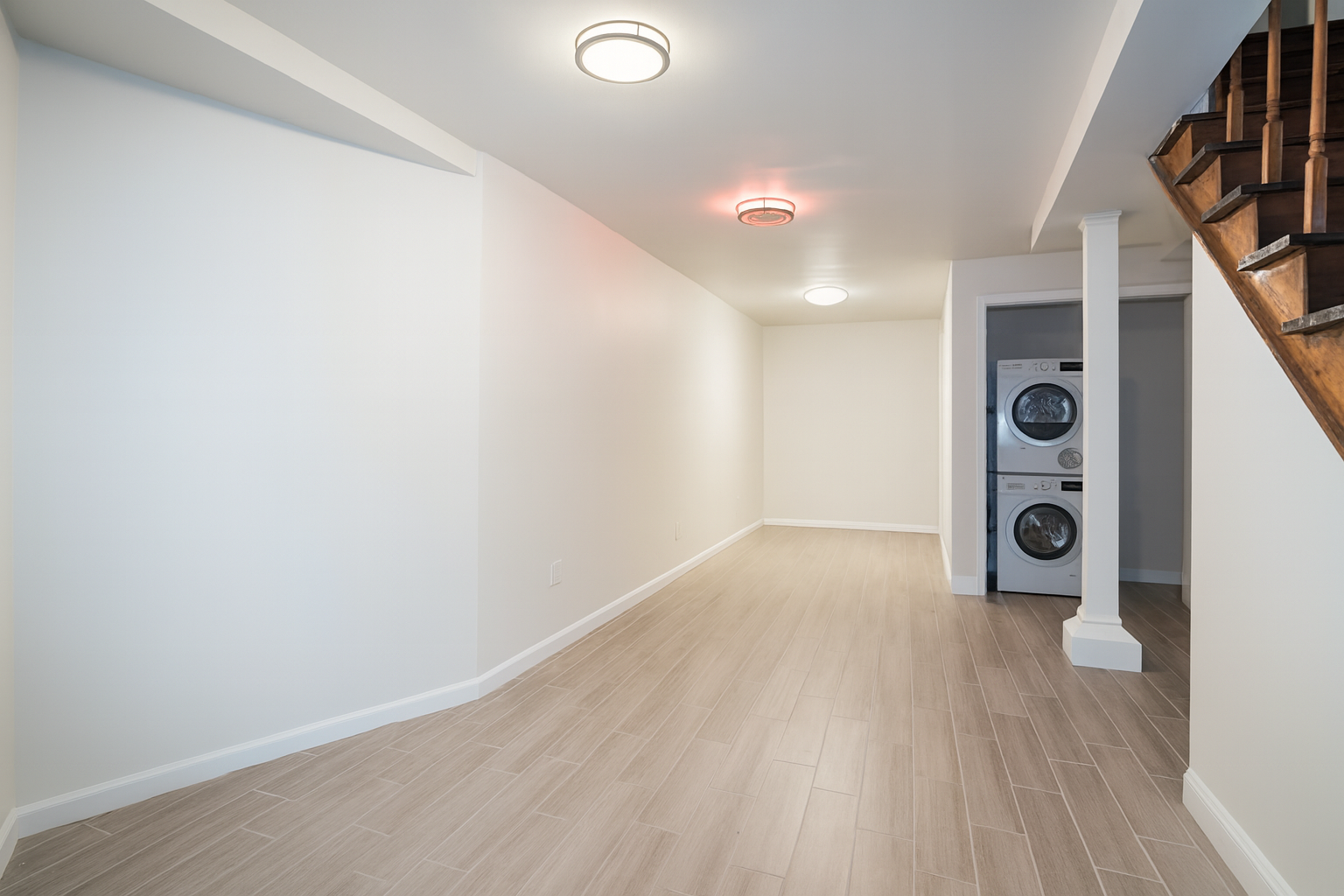 187 Woodpoint Road Brooklyn, NY 11211 - Photo 5 of 17 an empty room with wooden floor and windows