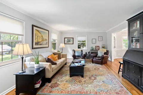 a living room with furniture fireplace and a large window