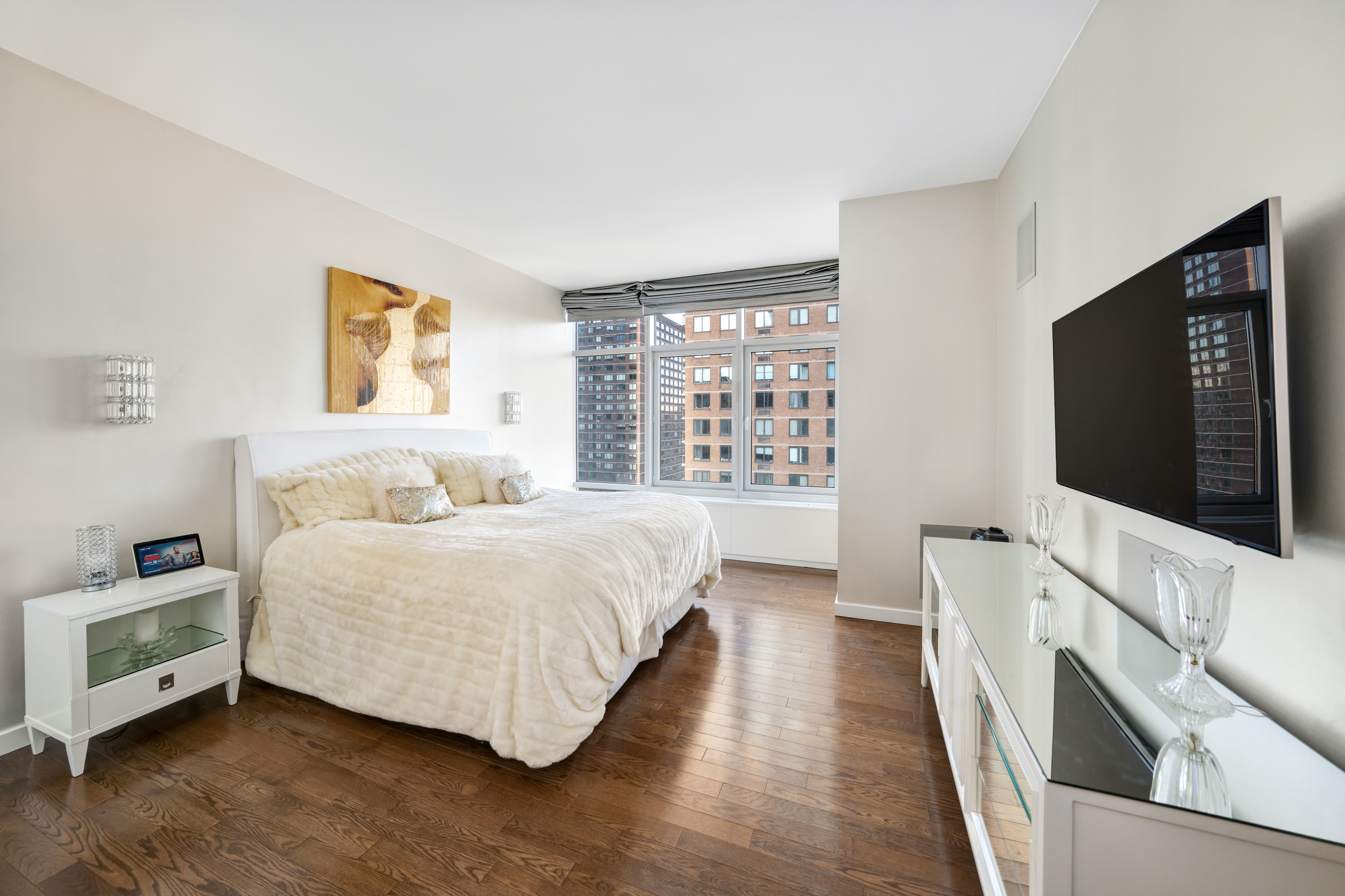 310 East 53rd Street, Unit 18A Manhattan, NY 10022 - Photo 11 of 19 a spacious bedroom with a bed and a flat screen tv