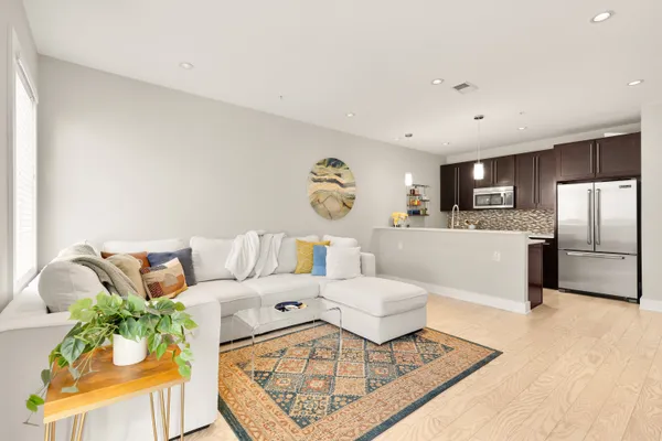 a living room with furniture and kitchen view