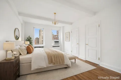 a bedroom with a large bed and a chandelier