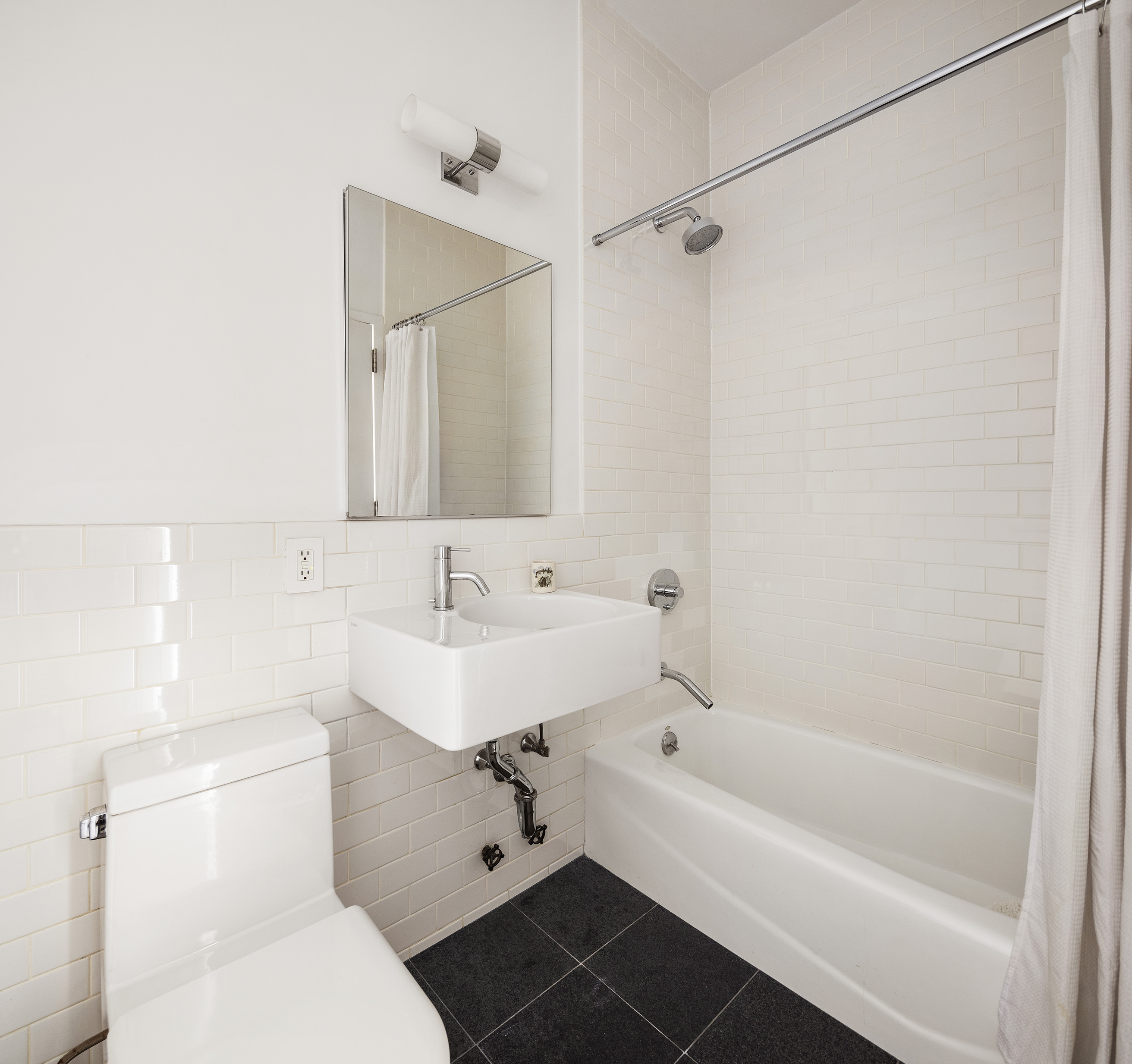 175 East Broadway, Unit 6A Manhattan, NY 10002 - Photo 6 of 11 a bathroom with a sink toilet and shower