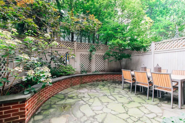 a backyard of a house with large trees and plants