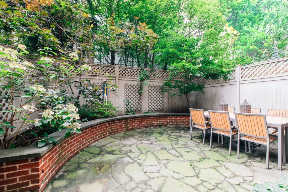 a backyard of a house with large trees and plants