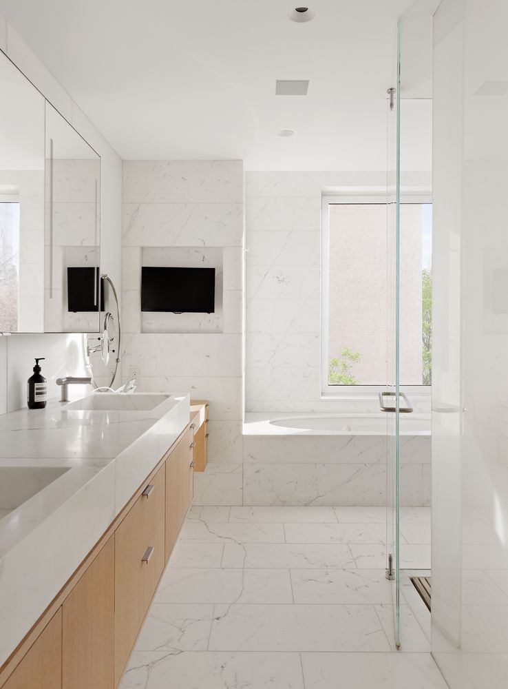 a bathroom with a double vanity sink a mirror and a bathtub