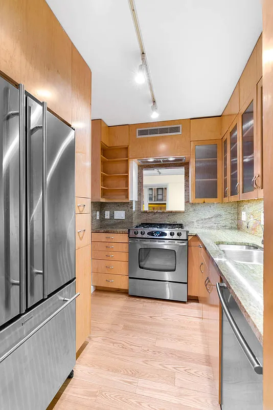 333 East 66th Street, Unit 2FE Manhattan, NY 10065 - Photo 5 of 19 a kitchen with stainless steel appliances granite countertop a refrigerator and stove