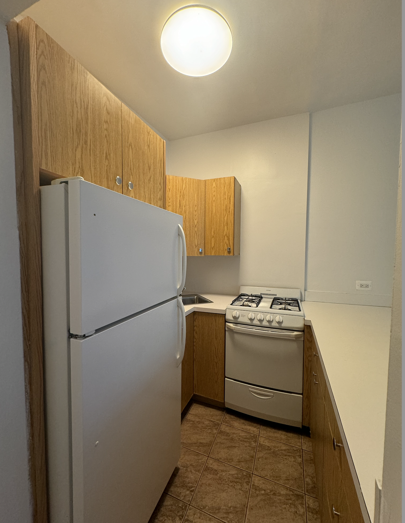 445 West 48th Street, Unit 2D Manhattan, NY 10036 - Photo 4 of 18 a kitchen with a refrigerator and a stove