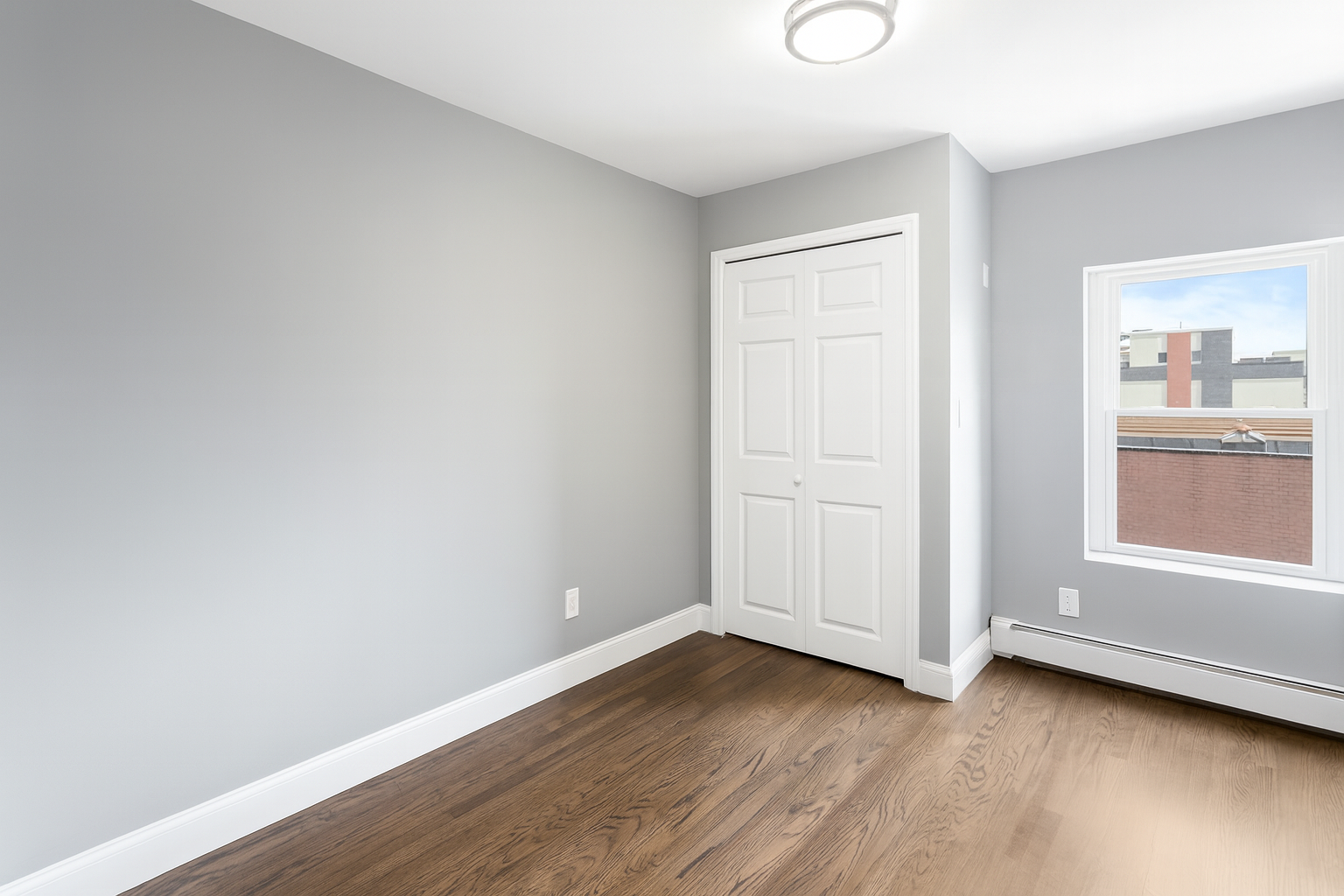 189 Woodpoint Road Brooklyn, NY 11211 - Photo 7 of 21 an empty room with wooden floor and windows