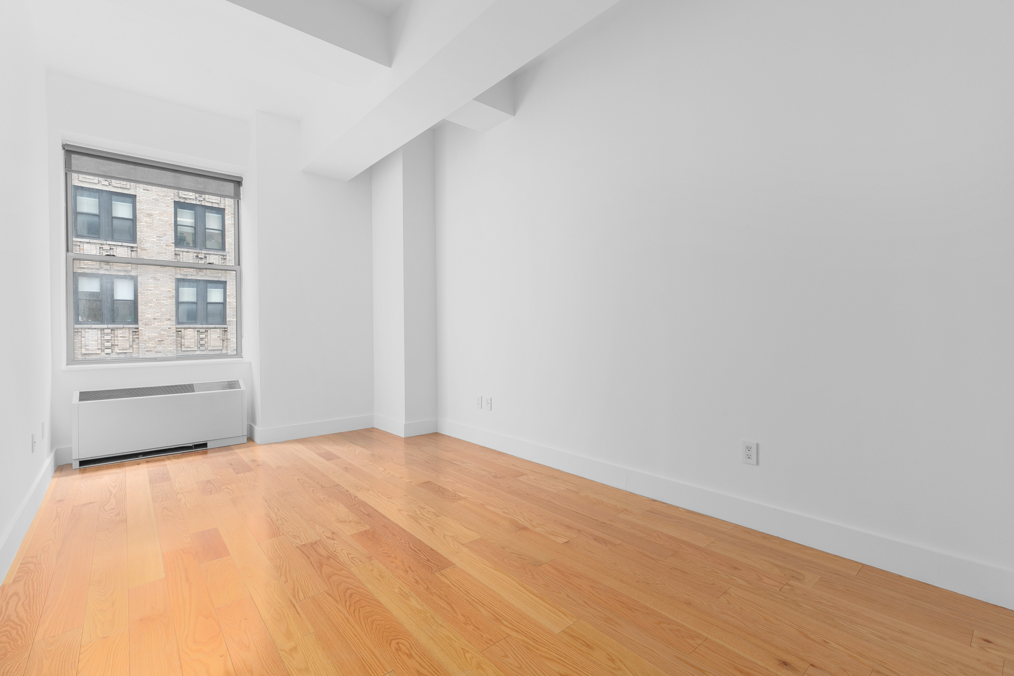 99 John Street, Unit 819 Manhattan, NY 10038 - Photo 6 of 20 a view of an empty room with a window