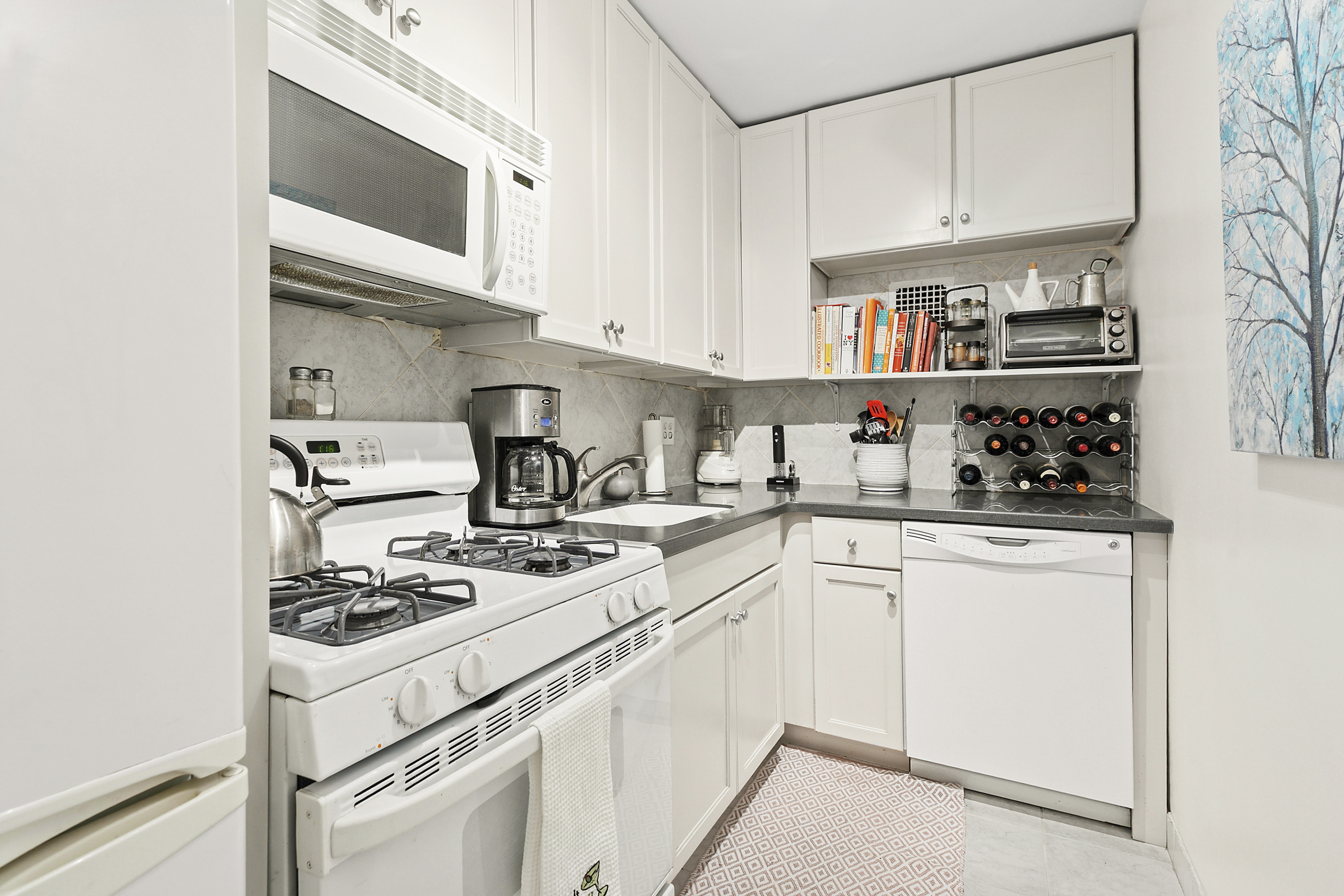 435 East 65th Street, Unit 3G Manhattan, NY 10065 - Photo 3 of 6 a kitchen with stainless steel appliances granite countertop white cabinets and white stove