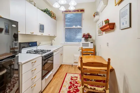 a kitchen with a stove and white cabinets