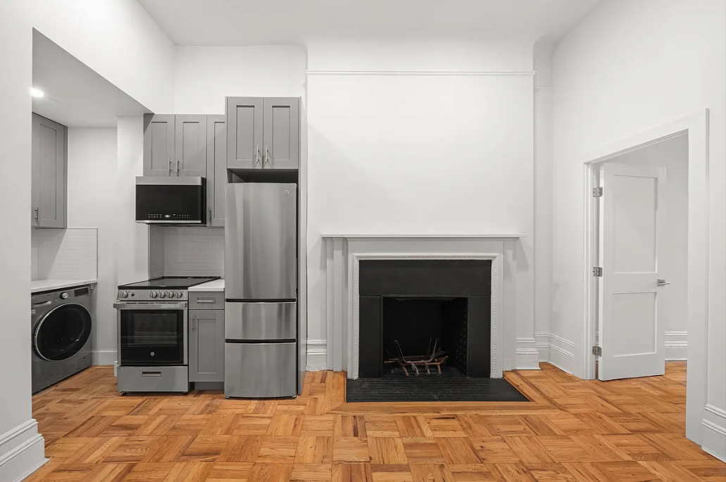 62 West 87th Street, Unit 1F Manhattan, NY 10024 - Photo 2 of 6 a kitchen with stainless steel appliances granite countertop a stove top oven a refrigerator and a fireplace