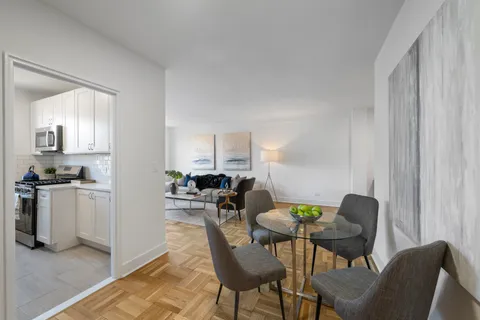 a view of a dining room with furniture and a kitchen