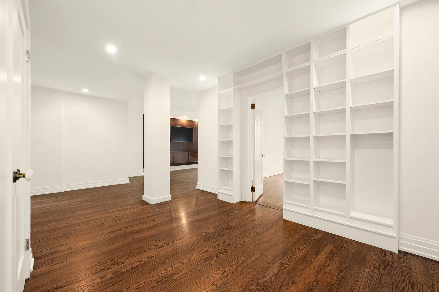 a view of empty room with wooden floor and entryway