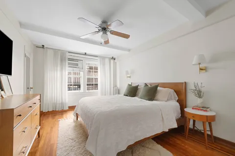 a bedroom with a bed a flat screen tv and couches