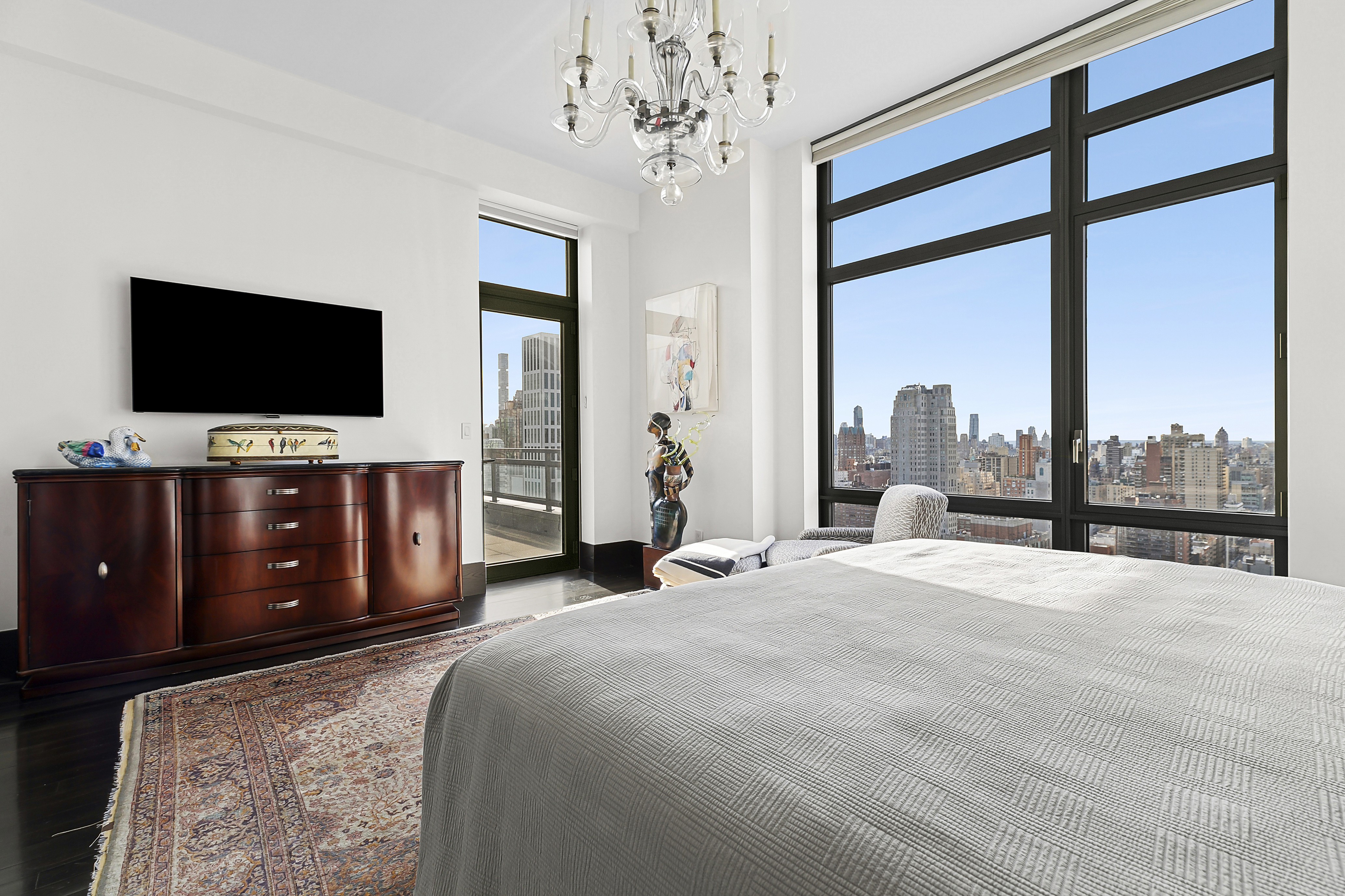 450 East 83rd Street, Unit PH1B Manhattan, NY 10028 - Photo 8 of 15 a bedroom with a bed and a flat screen tv