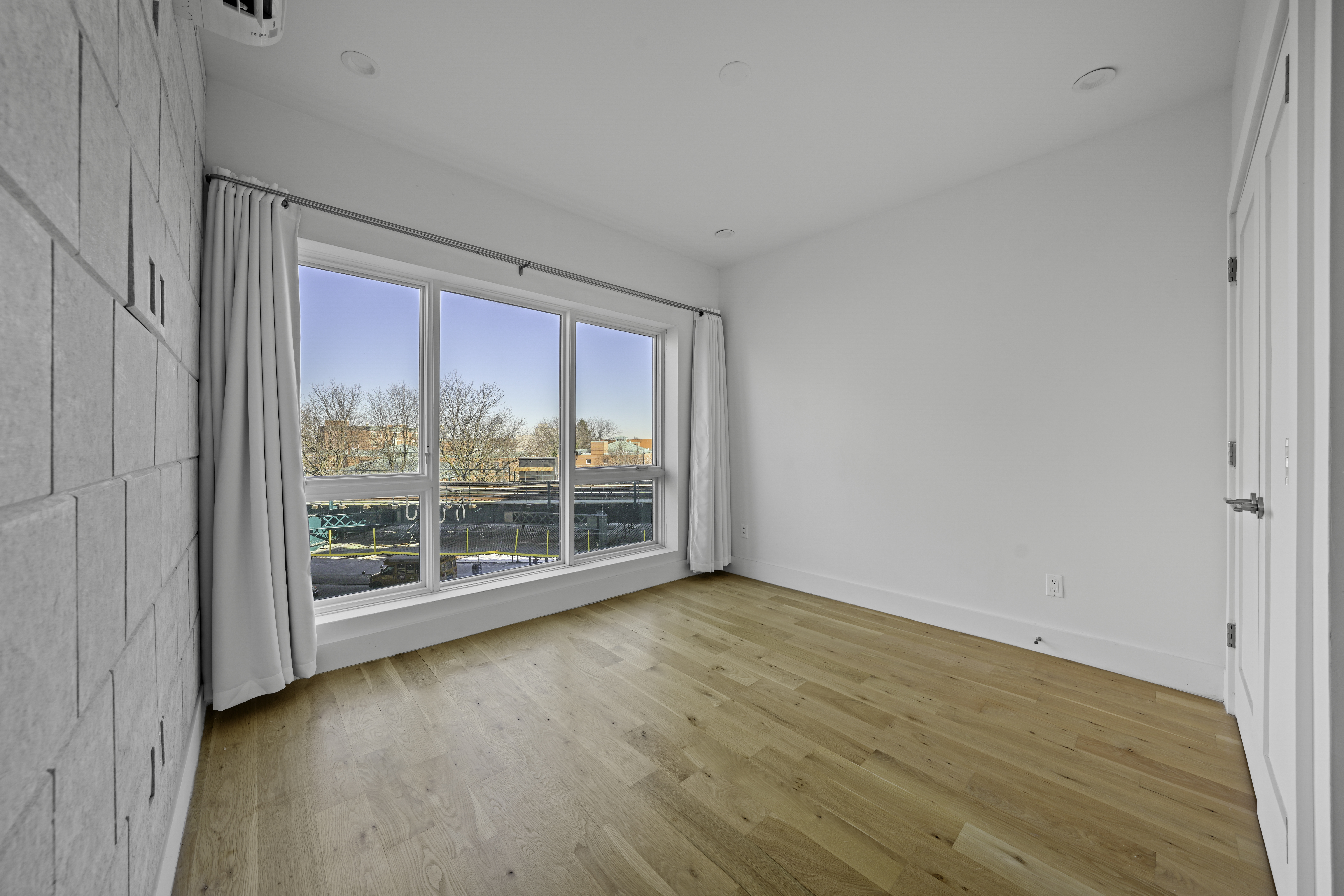 766 Decatur Street, Unit 4A Brooklyn, NY 11233 - Photo 5 of 12 a view of an empty room with wooden floor and a window