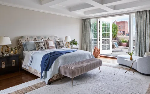 a spacious bedroom with a bed and a couch next to a window