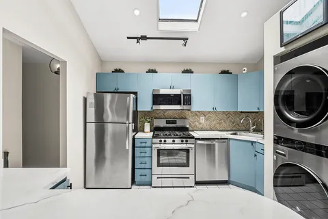 a kitchen with a stove top oven and refrigerator