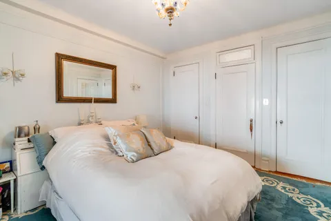 a bedroom with a bed and a painting on the wall