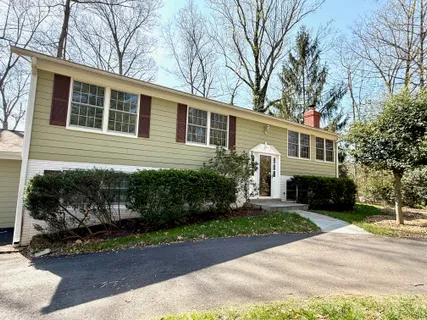 a front view of a house with a yard and potted plants