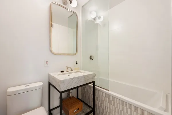 a bathroom with a sink a toilet and shower