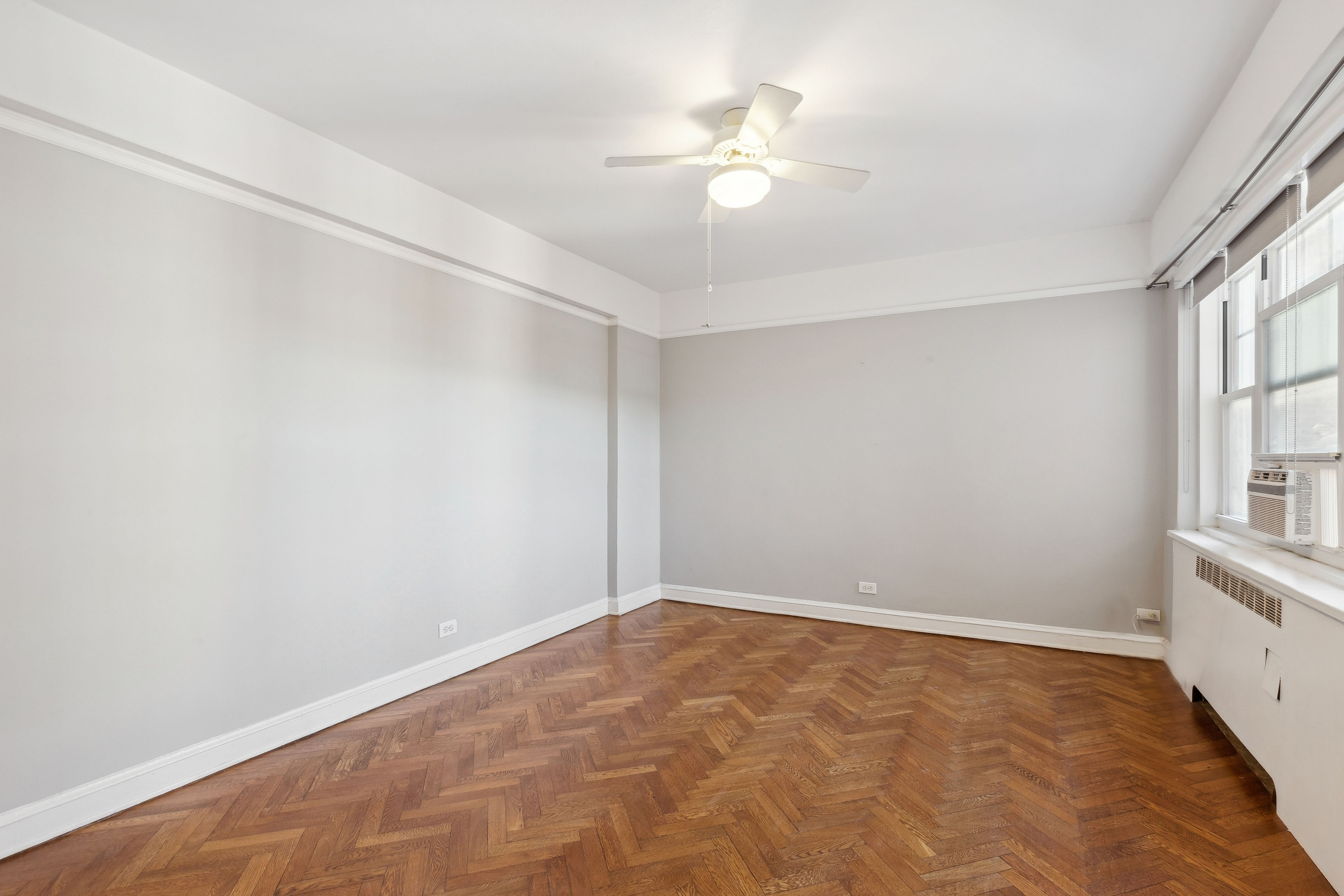 120 Cabrini Boulevard, Unit 107 Manhattan, NY 10033 - Photo 13 of 26 an empty room with windows and fan