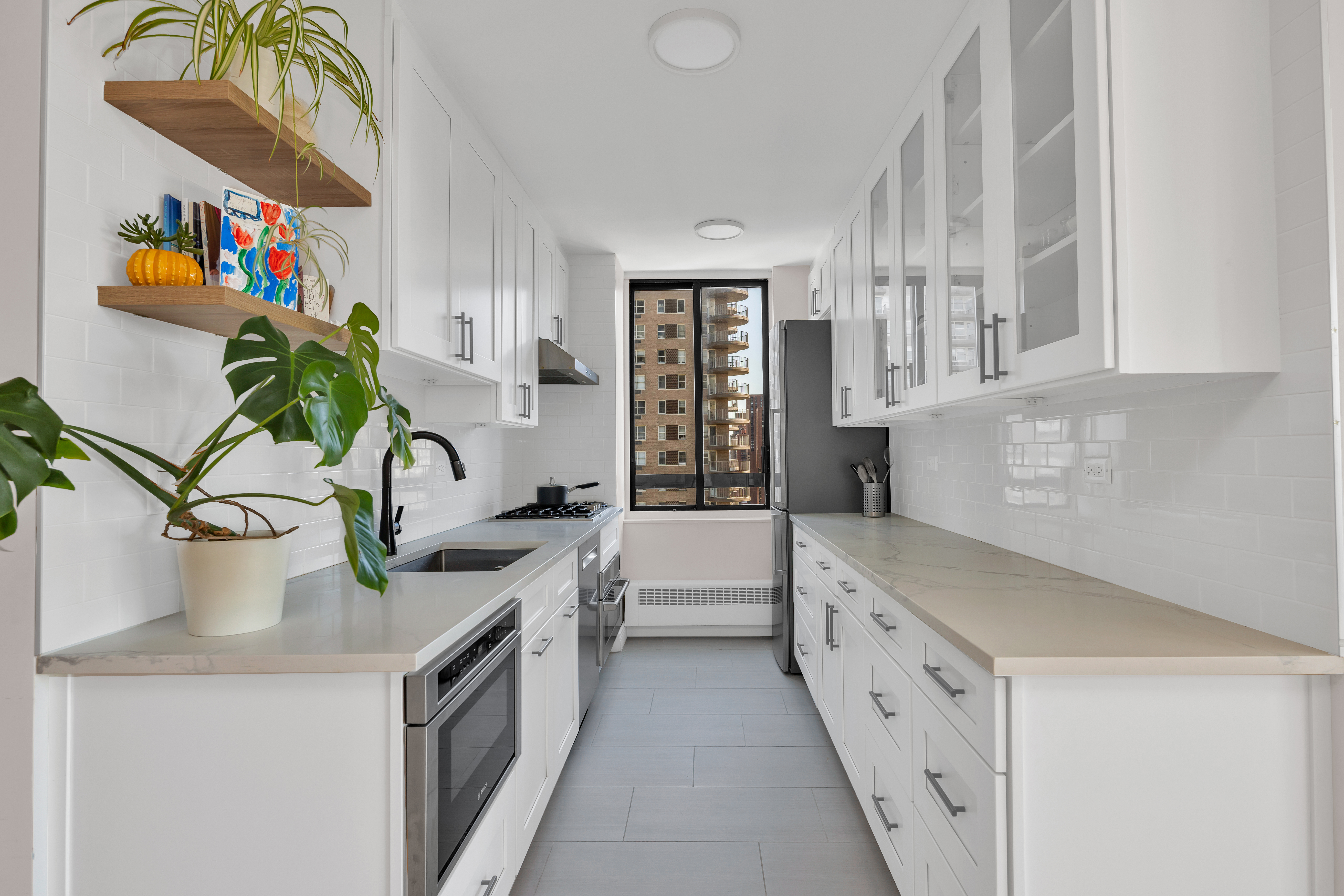 171 East 84th Street, Unit 22C Manhattan, NY 10028 - Photo 5 of 17 a kitchen with stainless steel appliances sink and cabinets