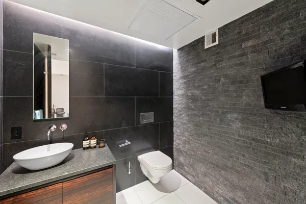 a bathroom with a granite countertop toilet sink and mirror